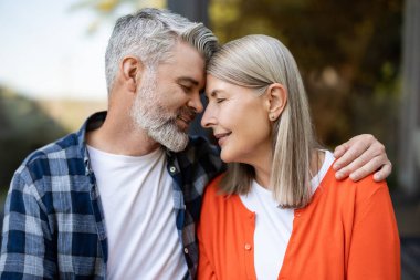Şefkatle sarılın. Gri saçlı sakallı adam kadına nazikçe sarılıyor ve ikisi de rahatlamış hissediyor.