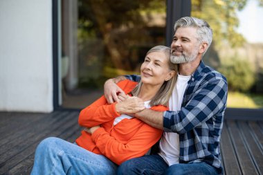 Şefkatle sarılın. Gri saçlı sakallı adam kadına nazikçe sarılıyor ve ikisi de rahatlamış hissediyor.