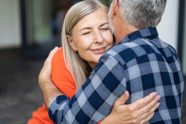 Mutlu kucaklaşmalar. Erkek ve kadın birbirlerine sarılıyor ve mutlu ve aşık görünüyorlar.