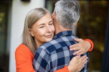 Mutlu kucaklaşmalar. Erkek ve kadın birbirlerine sarılıyor ve mutlu ve aşık görünüyorlar.