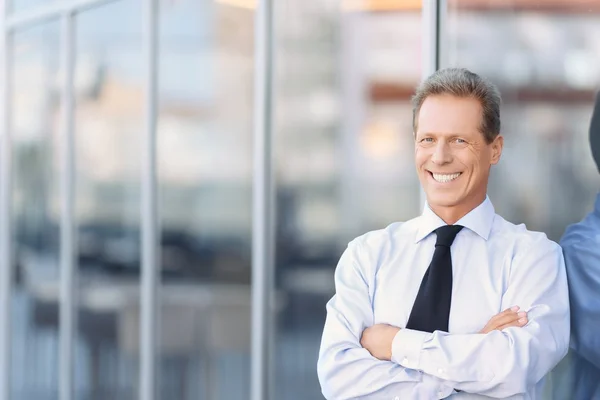 Хороший бизнесмен стоит рядом с офисным зданием — стоковое фото