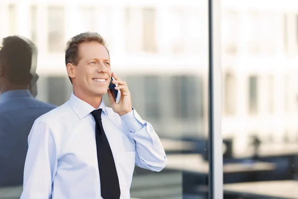 Nice businessman standing near office building — Stock fotografie