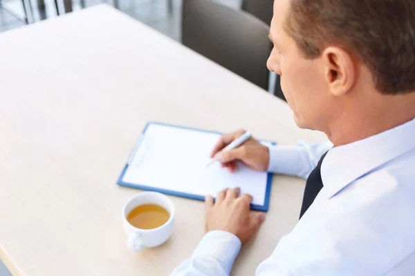 Bonito homem de negócios sentado à mesa — Fotografia de Stock