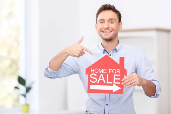 Pleasant realtor holding card — Stock Photo, Image