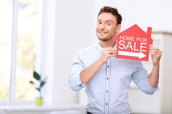 Pleasant realtor holding card