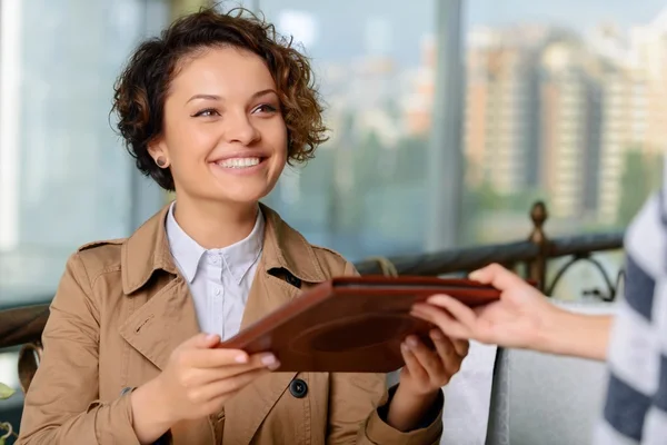 Girl getting menu while evincing positivity — Stok fotoğraf