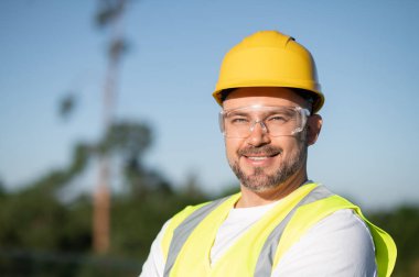 Açık mavi gökyüzünün altında profesyonel güneş teknisyeni portresi