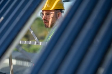 İşçi erkek gündüz vakti çatıya yenilenebilir enerji sistemi kuruyor.