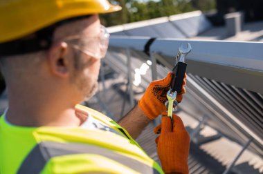 Miğferli erkek mühendis güneş paneli bakımı yapıyor.