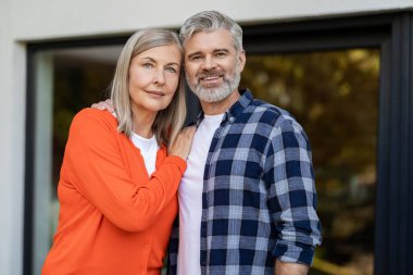 Evin girişinde. Evin girişinde iki kişi var ve memnun görünüyorlar.