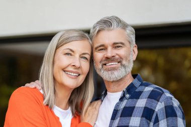 Evin girişinde. Evin girişinde iki kişi var ve memnun görünüyorlar.