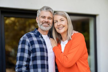 Evin girişinde. Evin girişinde iki kişi var ve memnun görünüyorlar.