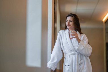 Rahatlamış hissediyorum. Beyaz bornozlu tatlı genç kadın rahat ve rahat hissediyor.