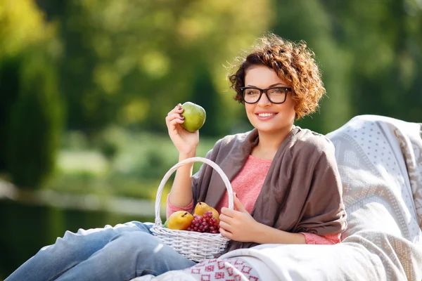 Menina agradável segurando frutas — Fotografia de Stock