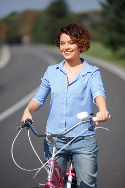Chica activa montando una bicicleta — Foto de Stock
