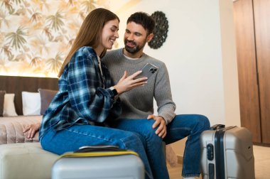 Otele varış. Geldikten sonra bir otel odasındaki yatakta oturan çift.