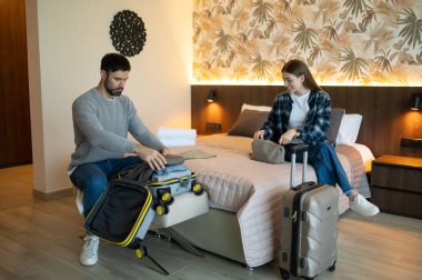 Eşyalarımı yerleştiriyorum. Genç çift tatil için otele vardıktan sonra bavullarını boşaltıyor.