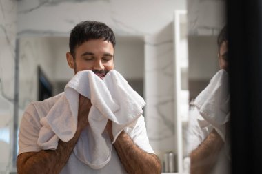 Yüzünü yıka. Beyaz sakallı genç adam sabah yıkanma ritüelini gerçekleştiriyor.