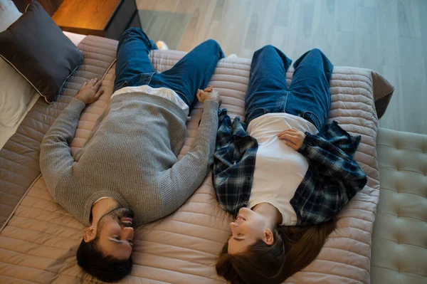 Bir otel odasında. Genç çift bir otel odasında yatakta uzanıyor ve rahatlıyorlar.