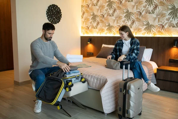 Eşyalarımı yerleştiriyorum. Genç çift tatil için otele vardıktan sonra bavullarını boşaltıyor.