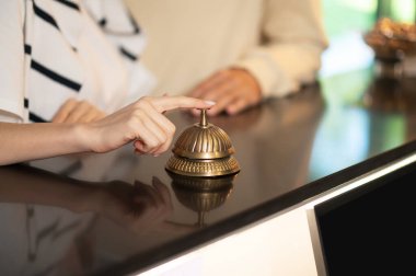 Resepsiyon. Bir elin resepsiyon zilini çaldığı resmi kapat.