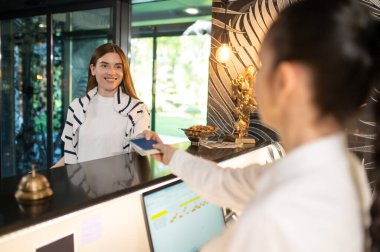 Otele varış. Yeni ziyaretçilerin konaklamasını ayarlayan ve pasaport alan resepsiyonist.