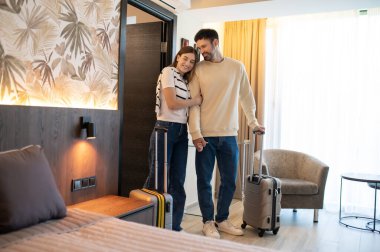 Geldik. Oteldeki odalarında bavullarıyla bir çift.