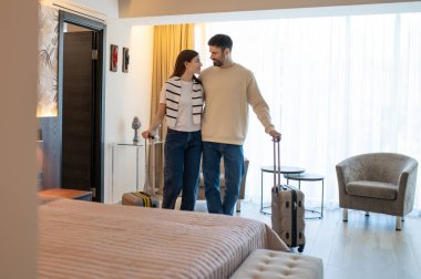 Geldik. Oteldeki odalarında bavullarıyla bir çift.