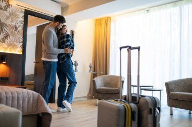 Tatil başlıyor. Otel odasındaki mutlu çift heyecanlı ve eğleniyor.