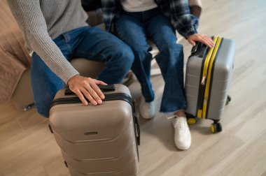 Otele varış. Geldikten sonra bir otel odasındaki yatakta oturan çift.