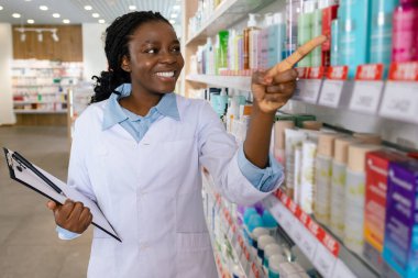 Eczanede. Eczanede laboratuvar önlüklü Afrikalı Amerikalı genç bir kadın.