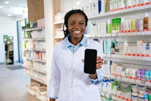 Pozitif eczacı. Laboratuvar önlüklü, mutlu ve mutlu gülümseyen genç bir kadın.