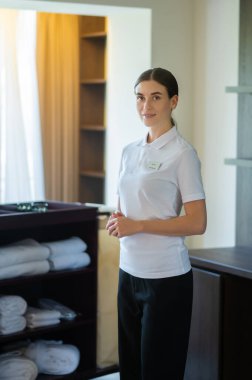 İş yerinde. Otel kadın hizmetlisi üniformalı, otel takımı giymiş.