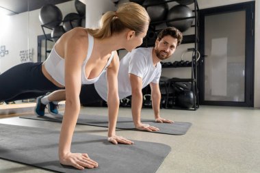 Tahtada dikiliyorum. Birlikte egzersiz yapan ve bir tahtanın üzerinde duran iki genç insan.