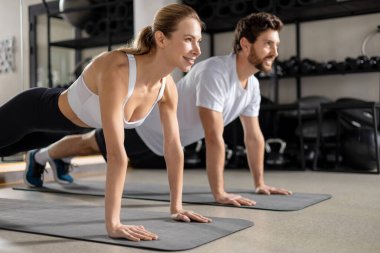 Tahtada dikiliyorum. Birlikte egzersiz yapan ve bir tahtanın üzerinde duran iki genç insan.