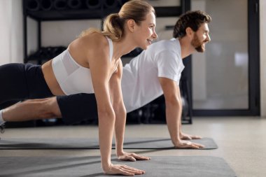 Antrenman yapıyorum. Spor salonunda antrenman yapan ve tahta üzerinde duran iki kişi.