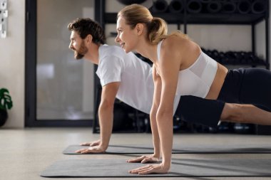 Antrenman yapıyorum. Spor salonunda antrenman yapan ve tahta üzerinde duran iki kişi.