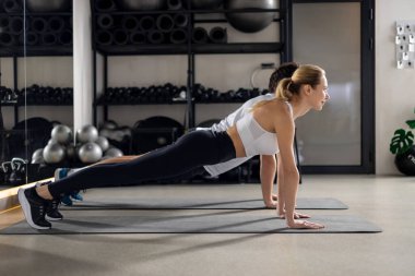 Antrenman yapıyorum. Spor salonunda antrenman yapan ve tahta üzerinde duran iki kişi.