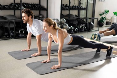 Antrenman yapıyorum. Spor salonunda antrenman yapan ve tahta üzerinde duran iki kişi.