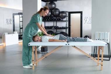 Terapi esnemesi. Kadın terapist nazikçe bacaklarını uzatıyordu.