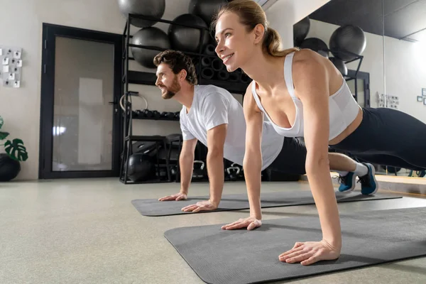 Tahtada dikiliyorum. Birlikte egzersiz yapan ve bir tahtanın üzerinde duran iki genç insan.