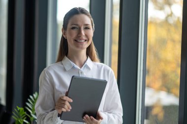 Bayan menajer. Ofisteki pencerenin yanında duran genç bayan yönetici.