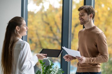 Ofiste birlikte çalışın. İş arkadaşları kahve içip proje detaylarını tartışıyor.