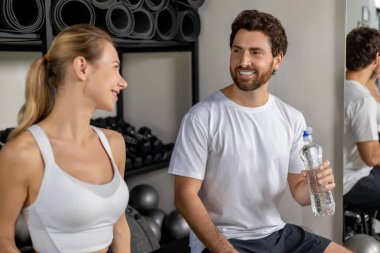 Spor salonundaki konuşma. Genç adam ve kadın spor salonunda iyi bir çalışmadan sonra konuşuyorlar.