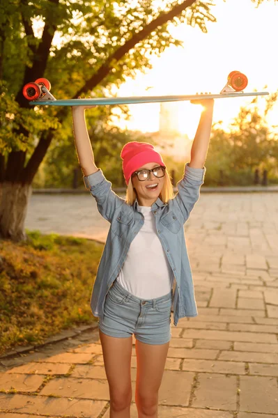 Overjoyed girl holding skateboard — Stockfoto