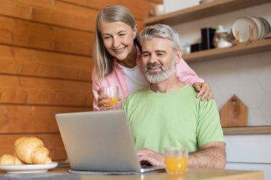 Olgun erkek ve kadın internette geziniyor.