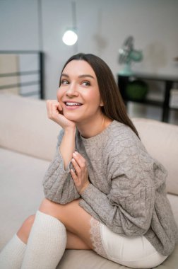 Yaramaz ruh hali. Uzun saçlı, beyaz tenli bir kadın evde yaramazlık yapıyor.