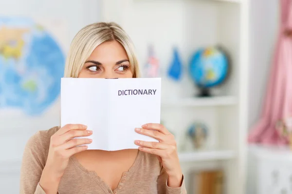 Nice girl reading dictionary — Stock Fotó