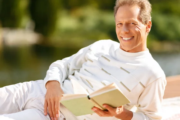 Angenehmer Mann liest ein Buch — Stockfoto