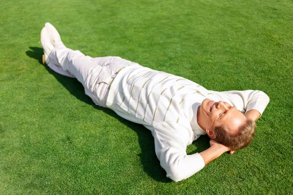 Aangenaam man liggen op het gras — Stockfoto